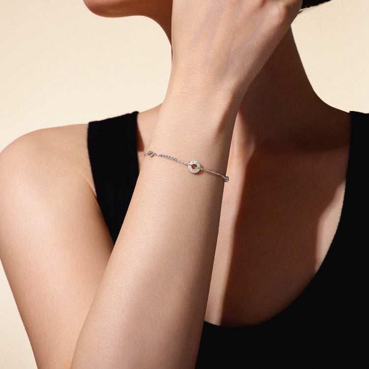 A model wearing Just Cléamoi bracelet, which is 18k white gold with a small circle design on a chain.