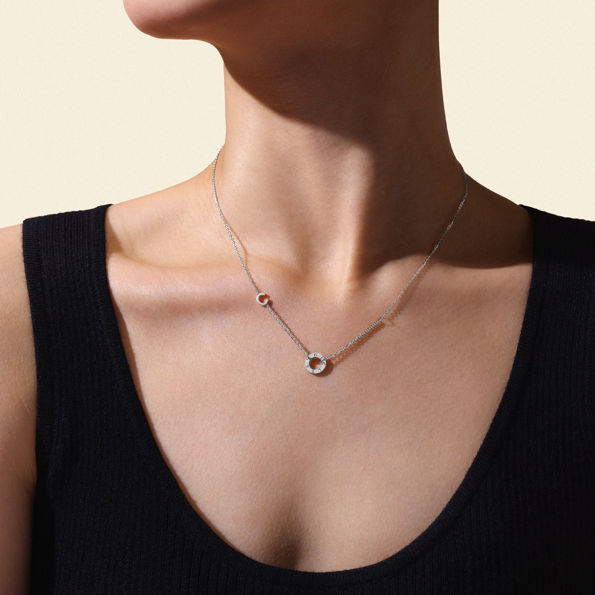 Model wearing a delicate white gold necklace against a neutral background
