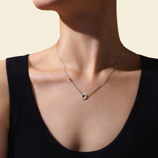Model wearing a delicate white gold necklace against a neutral background