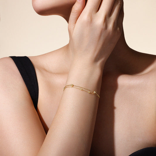 Model wearing The Joy Bracelet in solid 18k (750) yellow gold designed for everyday wear.