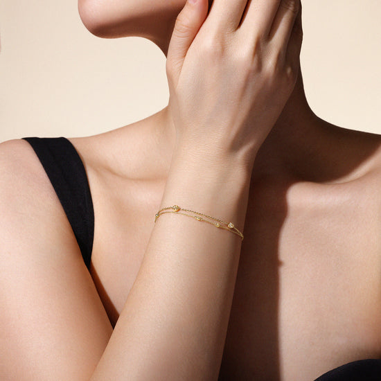 Model wearing The Joy Bracelet in solid 18k (750) yellow gold designed for everyday wear.