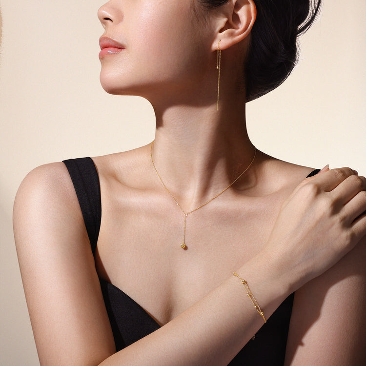 Model wearing matching Joy Collection necklace, bracelet and earrings crafted in solid 18k (750) yellow gold.