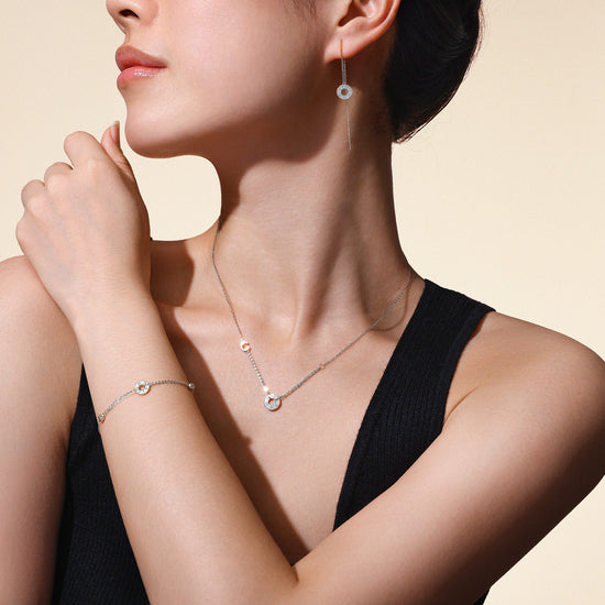 Model wearing matching Just Collection necklace, bracelet and earrings crafted in solid 18k (750) white gold.